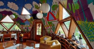 比亚里卡Tierra de Domos的一间设有桌椅和色彩缤纷的天花板的用餐室