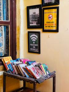 斋沙默尔Saffron Homestay的一堆书放在房间里长凳上