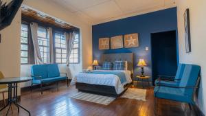 圣何塞Finca Escalante的一间拥有蓝色墙壁的卧室,配有一张床和蓝色的椅子