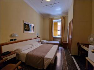 热那亚阿尔伯格博卡戴瑟酒店的配有一张床和一张书桌的酒店客房