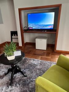 圣地亚哥HOTEL BOUTIQUE CASA NOBLE SPA的客厅配有电视、沙发和桌子
