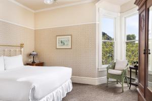 太平洋丛林Centrella Hotel, a Kirkwood Collection Hotel的一间卧室设有一张床、一个窗口和一把椅子