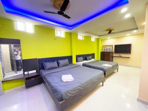 普里ojotrip Hotel Basanti INN- puri的一间卧室设有两张床和蓝色的天花板