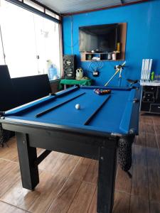 圣加布里埃尔Pousada Recanto do Coruja的蓝色墙壁的房间里一张台球桌
