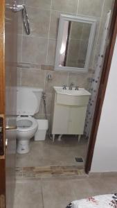 瓜莱瓜伊Alojamiento Guemes的一间带卫生间、水槽和镜子的浴室