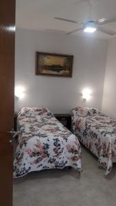 瓜莱瓜伊Alojamiento Guemes的卧室配有两张床,墙上挂着一幅画