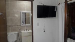瓜莱瓜伊Alojamiento Guemes的一间带卫生间的浴室和墙上的电视