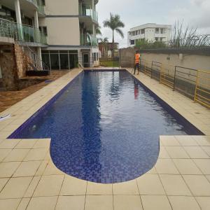 MutumbaParadise Appartment hotel的站在游泳池前的人