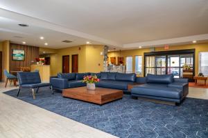 托皮卡Endeavor Inn & Suites, Trademark Collection by Wyndham的客厅配有蓝色的沙发和桌子