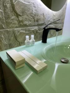 OkinniTD’s place的浴室柜台设有水槽和2个肥皂瓶