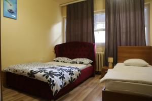 普里什蒂纳Moon Hostel的一间卧室配有两张床和红色椅子