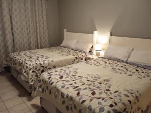 德班East-Coast Guesthouse: Serene, Private, Secure的配有衬衫的酒店客房内的两张床