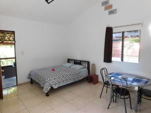 萨玛拉Villasjungle 1的卧室配有一张床和一张桌子及椅子