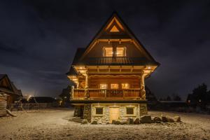 穆扎希赫尔Domek Na Przełęczy wood house & mountain view的小木屋 - 带阳台(晚上)
