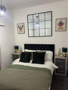 曼彻斯特Short Stopzzz & Indoor Hot Tub的一间卧室配有一张带2个床头柜和2盏灯的床。