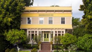 圣路易斯-奥比斯保Garden Street Inn Downtown San Luis Obispo, A Kirkwood Collection Hotel的一座古老的黄色房子,设有绿门