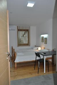 索科矿泉村SMEŠTAJ SOLARIS Studio Apartmani的卧室配有1张床、1张桌子和1张桌子以及椅子。
