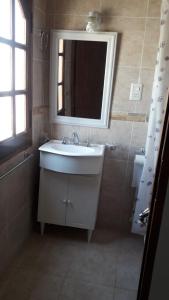 瓜莱瓜伊Alojamiento Guemes的浴室设有白色水槽和镜子