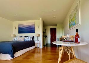 欧尼罗亚Watermark Apartments的一间卧室配有一张床和一张桌子及一瓶葡萄酒
