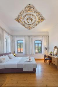埃雷索斯Eressian Hotel & Hammam Spa的一间大卧室,配有一张大床和吊灯