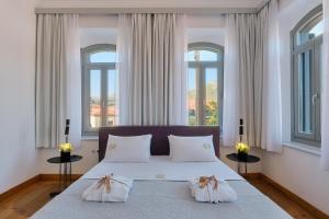 埃雷索斯Eressian Hotel & Hammam Spa的一间卧室配有带2个枕头的床和2个窗户。