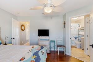 纳瓦拉Gulf Island 412的一间卧室配有一张床和一台平面电视