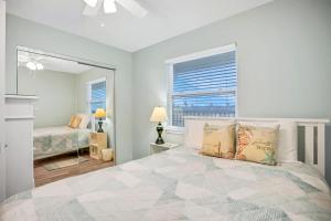 费南迪纳比奇306 Coral Sands的一间卧室设有一张大床和一个窗户。