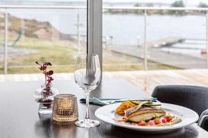 奥斯卡港科拉勒贝斯特韦斯特酒店的一张桌子,上面放着一盘食物和一杯葡萄酒