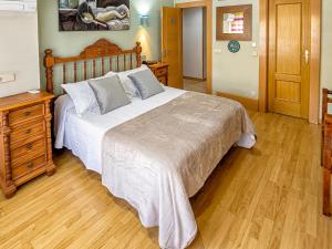 阿兰约兹里尔阿兰胡埃斯旅馆的一间卧室配有一张大床和一个木制梳妆台