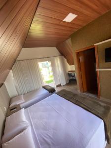 布鲁马迪纽Chalezinho Pousada的一间卧室设有两张床和木制天花板