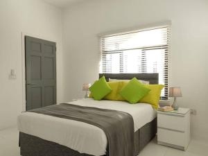 Clifton FallsThe Willow Apartment的一间卧室配有一张带黄色枕头的床和一扇窗户