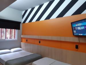 维多利亚Artsy Vitoria Hostel的客房设有两张床和一台平面电视。