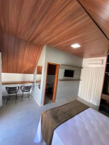 布鲁马迪纽Chalezinho Pousada的卧室配有一张床和一张桌子及椅子