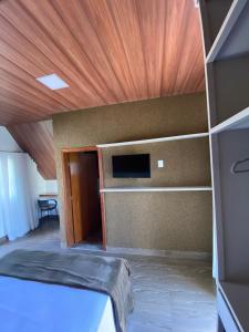 布鲁马迪纽Chalezinho Pousada的客房设有一张床和木制天花板