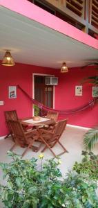因巴塞Imbassai - Casa Alto Padrão completa - Condominio Fechado - A2B1的红色墙壁前带桌椅的天井