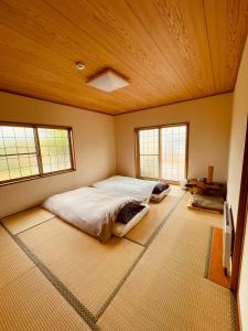 弘前市HIROSAKI清水森はうす的一间卧室设有一张大床和两个窗户