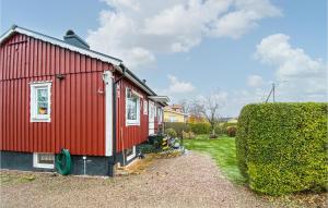 拉霍尔姆Lovely Home In Laholm With Wifi的旁边是一座红色房子,有树 ⁇ 