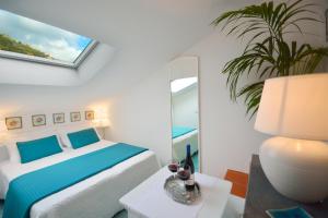 米诺利托雷天堂公寓式酒店的白色卧室配有床和镜子