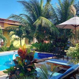 皮帕Villa da Praia的一个带游泳池和棕榈树的度假村