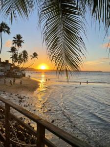 皮帕Villa da Praia的棕榈树海滩上的日落