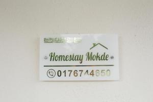 麻坡Homestay Mokde的墙上家用保证模块的标志