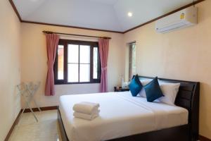 查汶新别墅酒店的卧室配有带蓝色枕头的大型白色床