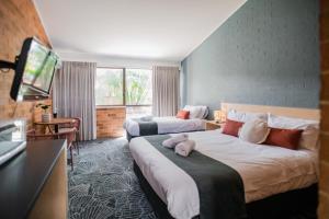 贝尔拉拉Bribie Island Hotel的酒店客房设有两张床和一台平面电视。