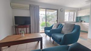 黄金海岸K Resort Surfers Paradise Apartments的客厅配有2把蓝色椅子和桌子