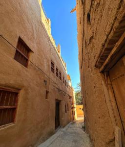 阿尔哈姆拉AL Hamra Heritage Inn的老城区两栋建筑之间的小巷