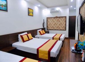 下龙湾Tình Hiếu Hotel的酒店客房设有两张床和一台平面电视。