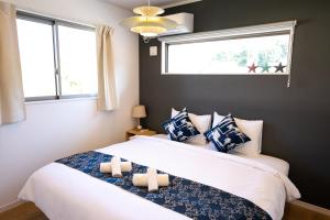 恩纳#3LDK一軒家 #長期滞在可能 #海まで4分-- Starry Sky Resort Okinawa --的一间卧室配有一张带两张蜡烛的床。
