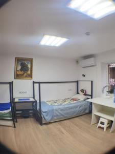 穆卡切沃Солензара的卧室配有一张床铺,位于带桌子的房间