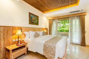 乌布Weda Cita Resort and Spa by Mahaputra的一间卧室设有一张大床和一个大窗户