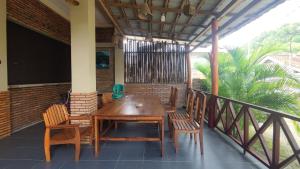 巴芝丹Bintang Homestay Watukarung的阳台上的木桌和椅子